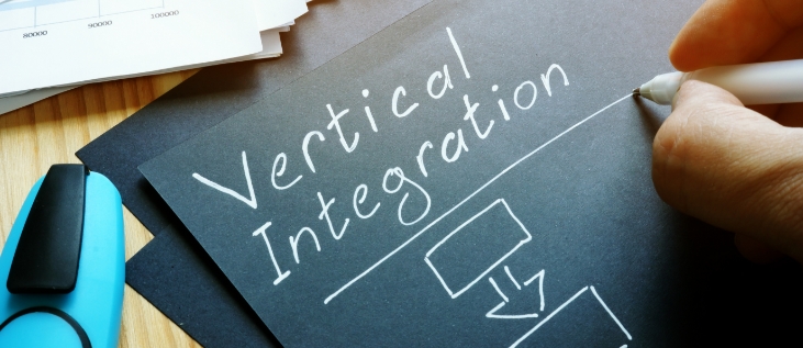 vertical integration being written on a black piece of paper with white ink